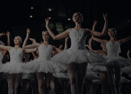 A group of women in white tutus are dancing.
