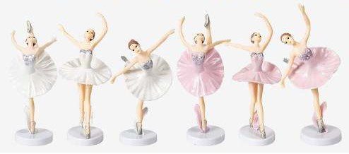 A set of four figurines that are dressed in ballet outfits.