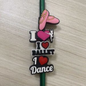 A pencil with magnets on it that say i love ballet, i dance and a pink shoe.