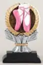 A pair of pink ballet shoes on top of a silver and black trophy.