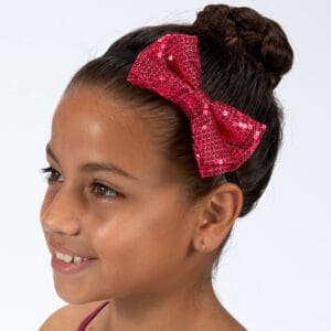 Young girl with braided hair and a red bow headband.