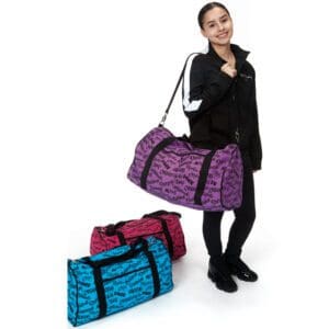 Woman carrying a purple duffel bag with two other colorful bags on the floor.