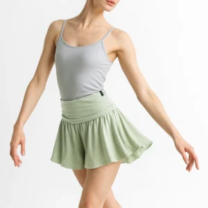 Woman in a gray tank top and green skirt posing gracefully.