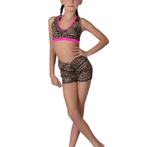 A young girl in leopard print dancewear posing confidently.