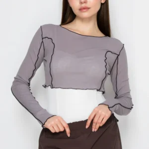 Woman wearing a stylish gray and white layered top with brown pants.